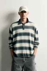 Polo relaxed fit de punto de algodón con diseño de rayas horizontales en tonos gris, beige y verde, cuello solapa con botonadura frontal y manga larga.