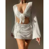 Conjunto de baño de cuatro piezas en color negro, confeccionado en tejido de malla transparente. Incluye un top de bikini triangular, una remera manga larga abierta con lazo frontal para anudar, y una pollera corta ajustable con cordones laterales.