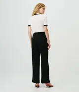 Pantalón wide leg de sastrería color negro, confeccionado en crepé, con cintura con pasacintos y corte de pernera ancha.