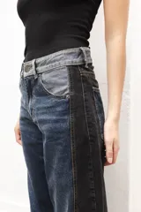 Jean de mujer de corte recto y tiro medio, con diseño patchwork en tonos de azul, gris y negro. Confeccionado en algodón.