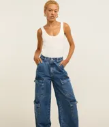 Pantalón estilo años 90 de tiro alto confeccionado en jean, con bolsillos cargo en los laterales y trabillas en la cintura.