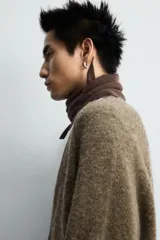 Cárdigan de punto con lana, color marrón, de corte relajado, cuello en pico, manga larga y cierre frontal con botones. Presenta puños y bajo en acabado rib.