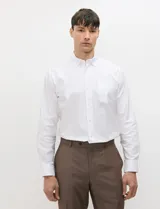 Camisa de manga larga de tejido Oxford color celeste, con cuello button-down, cierre frontal de botones y un bolsillo aplicado en el pecho.