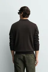 Sweater polo de punto de mezcla de algodón en color negro, con cuello solapa, abertura frontal y mangas largas con acabado en rib.
