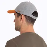 Gorro tipo jockey de Merrell con diseño bicolor, cuerpo en color gris y visera curva en color naranja. Presenta una letra M bordada en el frente y una pequeña etiqueta de cuero sintético en el lateral.