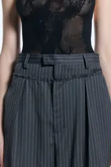 Pantalón sastrero de tiro alto con diseño rayado y fit amplio. Presenta una doble cintura con detalle descosido, pinzas delanteras y traseras, y bolsillos ojal en la parte posterior.