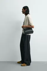 Camiseta de corte holgado y estilo cropped, color beige con efecto lavado. Presenta cuello redondo, mangas cortas y una estampa frontal con texto en azul que simula trazos de rotulador.
