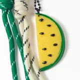 Llavero con mosquetón en forma de corazón, compuesto por cordones de nylon trenzados en colores verde y blanco, y un dije colgante de resina con forma de rodaja de sandía amarilla.