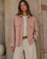 Camisa de lana merino color rosado viejo, de corte recto con bolsillos frontales con solapa y cierre de botones.