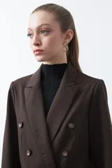 Blazer sastrero negro de doble botonadura con botones marrones, cuello solapa y mangas tres cuartos. Tiene dos bolsillos delanteros con solapa.