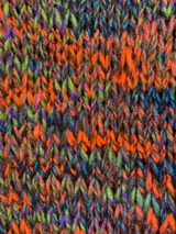 Sweater tejido a mano en lana color gris jaspeado, de calce holgado, con cuello a la base y puños ajustados.