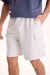 Bermuda cargo de felpa sin friza, color beige, con cintura elástica y bolsillos laterales con solapa.