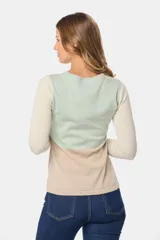 Buzo de tejido de punto con diseño de bloques de color en tonos verde menta, crema y beige. Presenta mangas largas y un panel inferior con textura de cableado.