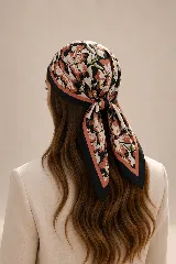 Pañuelo cuadrado de seda con estampado floral en tonos terracota, negro y crema, con borde negro y detalle de franja color salmón.