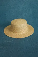 Sombrero de paja color beige, de ala ancha y copa cilíndrica.