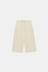 Pantalón culotte de lino en color beige con finas rayas verticales anaranjadas, tiro alto, cintura elástica con cordón de ajuste y bolsillos laterales.