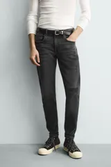 Jeans skinny fit de corte ajustado y tiro medio en color negro con efecto lavado y detalles desgastados. Confeccionados en tejido elástico con mezcla de algodón, presentan diseño clásico de cinco bolsillos y cierre frontal con cremallera y botón.