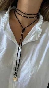 Gargantilla roja de múltiples vueltas con cuentas plateadas y dijes redondos.