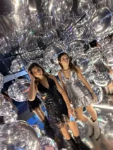 Vestido corto negro con estampado de plumas doradas, escote en V, breteles finos cruzados en la espalda, cut-outs laterales y volado en el ruedo.