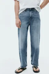 Jean de corte holgado estilo loose, confeccionado en denim de algodón grueso en tono azul claro con lavado desgastado. Presenta diseño de cinco bolsillos, tiro bajo y pierna ancha y redondeada.