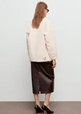 Chaqueta de algodón estilo denim en color beige, con diseño recto, cuello camisero de pana en contraste y cierre delantero de botones ocultos. Cuenta con manga larga y cuatro bolsillos delanteros de parche.