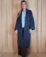 Sacón largo de punto abierto, confeccionado en lana, con diseño holgado, mangas anchas y cuello tipo solapa.