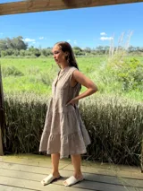 Vestido celeste de lino, sin mangas, con cuello mao y botones de nácar. Presenta varios cortes en su largo, aportando movimiento y un toque moderno a este diseño fresco y elegante.