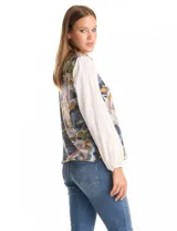 Buzo combinado con torso de tejido fino estampado con diseño floral en tonos azules, grises y rosados. Presenta mangas largas de gasa liviana en color blanco con puños elásticos y botones funcionales en los laterales del ruedo.