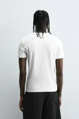 Camiseta gris de corte slim fit, confeccionada en tejido de algodón con elasticidad, cuello redondo y manga corta.