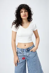 Top negro de algodón con mezcla de poliéster y elastano, con escote en V delantero y trasero.