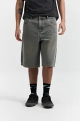 Bermuda de jean con calce baggy, de tiro medio y corte amplio en piernas y cadera. Presenta un lavado desgastado en tono grisáceo, con pasacintos y bolsillos laterales y traseros.