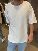 Remera de corte oversize en color blanco, confeccionada en tejido de algodón con textura acanalada, cuello redondo y mangas cortas.