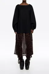 Vestido midi de corte holgado con diseño bimaterial. La parte superior simula una remera de manga larga en color negro, mientras que la falda presenta un estampado animal print en tonos marrones con bajo irregular y fluido.