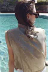 Top color tostado decorado con lentejuelas en el frente, cuello redondo y mangas sisa con detalles semitransparentes en cuello y sisas. Cuenta con cierre en la espalda con abertura y lazada.