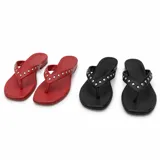 Sandalias de tipo cholas color negro con tiras de dedo decoradas con tachas metálicas plateadas.