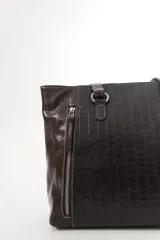 Cartera de cuero vacuno color marrón, de diseño amplio con paneles combinados de diferentes texturas y un panel central con relieve de cocodrilo. Cuenta con cierre frontal vertical y asas de hombro.