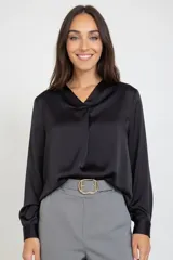 Blusa de satén color negro, con escote en V y mangas largas con puños. Presenta un diseño de corte relajado y acabado brillante.