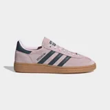 Championes Adidas modelo Handball Spezial, confeccionados en gamuza color rosado con las icónicas tres tiras y detalle en el talón en color azul oscuro. Presentan puntera en forma de T y suela de caucho color caramelo.