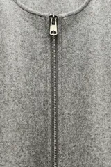 Chaqueta bomber de cuello redondo y manga larga con diseño holgado. Presenta cierre frontal con cremallera, bolsillos delanteros de vivo y acabados elásticos en los puños y el ruedo.