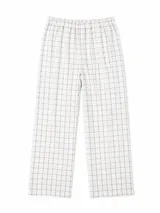 Pijama de dos piezas compuesto por una camisa de manga larga con cuello solapa, cierre frontal de botones y bolsillo en el pecho, y un pantalón de corte recto. Presenta un diseño de cuadrícula fina en color marrón sobre fondo blanco.