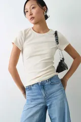 Remera de manga corta y cuello redondo confeccionada en suave tejido rib, con un diseño entallado al cuerpo.