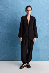 Blazer negro de corte relajado, con solapa clásica y cierre frontal.