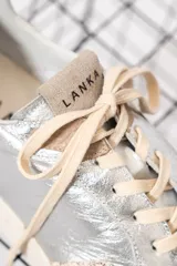 Championes plateados de cuero, con detalles en beige y suela color crema.