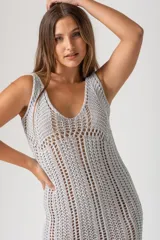 Vestido tejido al crochet color gris plata, de corte midi, con breteles finos y flecos en el ruedo.