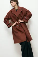 Abrigo de paño de lana con cuello alto estructurado, cierre frontal y mangas largas con detalle de botón en el puño.