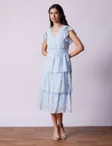 Vestido midi celeste de gasa estampada, marca Julia Jordan. Tiene escote en V, mangas cortas con volados y forro interno a tono.