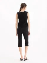 Pantalón tipo pescador negro de tiro alto, confeccionado en tejido de punto suave, con recortes en el centro delantero y tajos laterales en el ruedo.