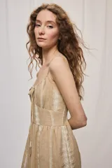 Vestido largo negro de algodón, con breteles finos, escote con frunce y lazo regulable. Tiene cintura definida y falda amplia escalonada, con detalles bordados verticales en contraste.