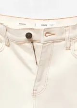 Jeans estilo mom-fit de tiro alto color beige, confeccionados en tejido elástico de algodón, con diseño de cinco bolsillos, trabillas y cierre frontal de cremallera y botón.
