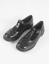 Mocasines negros de cuero vegano con detalle de tachas plateadas en la parte delantera.